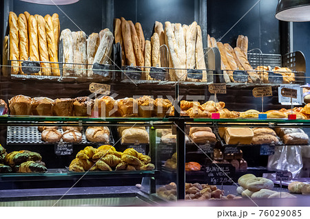 Sweet pastries, bread and baguettes on showcase in French bakery 76029085