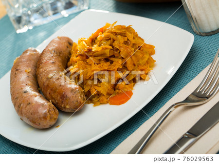 Sausages from meat served with braised cabbage, no people 76029563