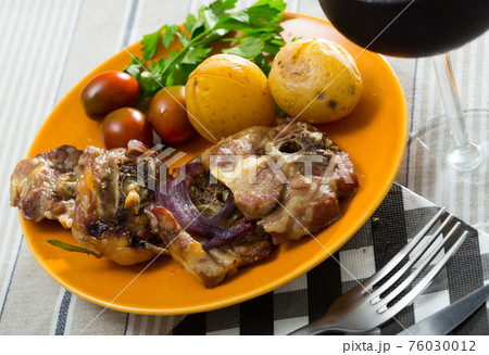 Lamb leg chops with baked potatoes, tomatoes and greens Lamb leg chops with baked potatoes, tomatoes and greens 76030012