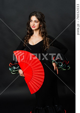 Portrait of beautiful young woman dancing flamenco in studio 76032033
