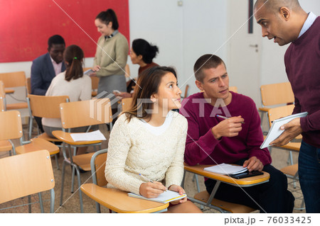 Adult students in cooperation with their school assignment Adult students in cooperation with their school assignment 76033425