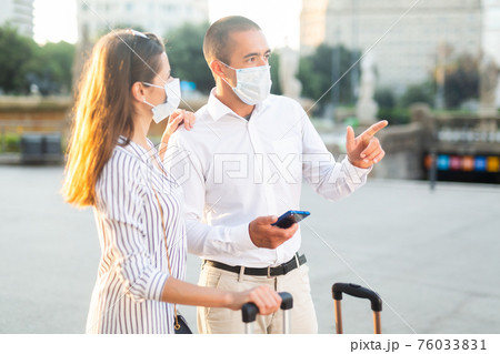 Tourist couple in medical masks visiting city attractions Tourist couple in medical masks visiting city attractions 76033831