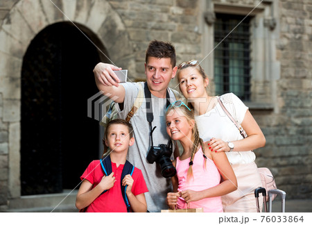 Family strolling on city streets and taking selfie Family strolling on city streets and taking selfie 76033864