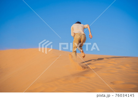 The person overcomes difficulties and aspires to the purpose and dream. A man overcomes difficulties in life as if in a desert The person overcomes difficulties and aspires to the purpose and dream. A man overcomes difficulties in life as if in a desert 76034145