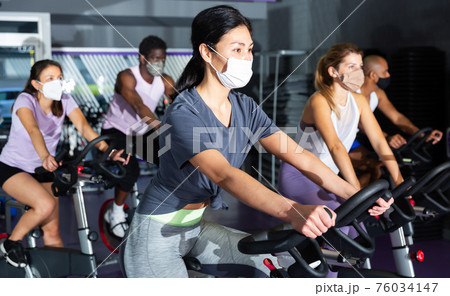 Woman training on cycling machine in gym Woman training on cycling machine in gym 76034147