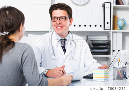 Doctor speaking with client in the medical center Doctor speaking with client in the medical center 76034232