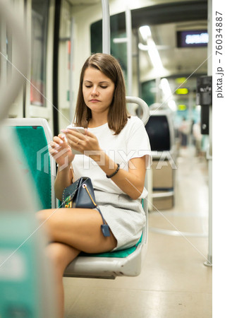 Female using mobile phone in tram Female using mobile phone in tram 76034887