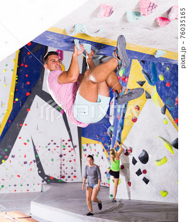 Sporty man training at bouldering gym Sporty man training at bouldering gym 76035165