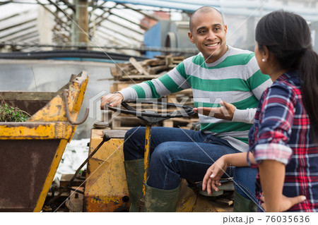 workers talking and discussing near forklift 76035636