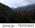 Construction of a new bridge in the Himalayan Mountains in the early cloudy morning. Two people at a height are building a bridge. 76035643
