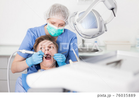 Young man on dental checkup in modern dentist office 76035889