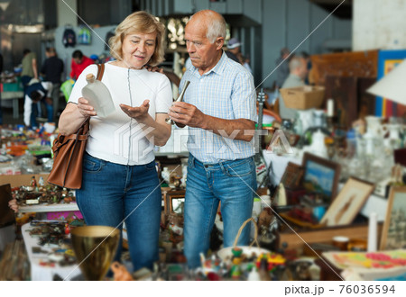 Elderly couple in flea market chooses antique items Elderly couple in flea market chooses antique items 76036594