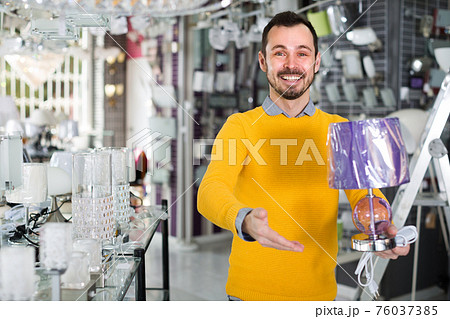 Male in lighter shop is choosing stylish and modern lamp Male in lighter shop is choosing stylish and modern lamp 76037385