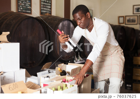 Winemaker inspecting wine bottles in store Winemaker inspecting wine bottles in store 76037625