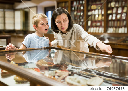 Woman and boy exploring artworks in museum 76037633