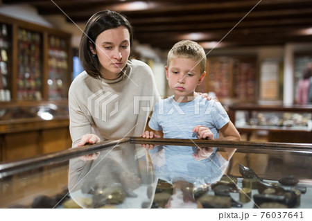 Woman and boy exploring artworks in museum 76037641
