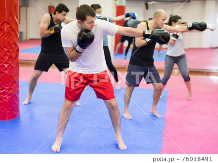 Young people practicing boxing punches 76038491