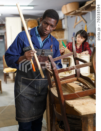 Professional restorer renewing vintage armchair 76038594