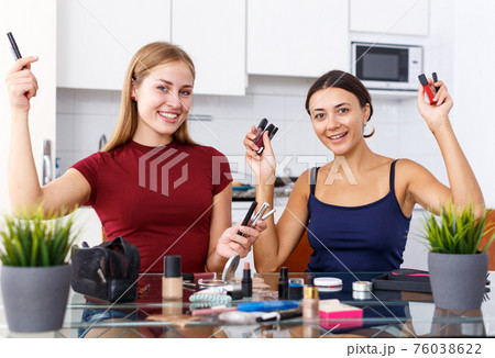 Two modern girls applying make up 76038622