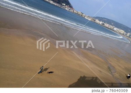 スペイン　ラ・コンチャ海岸で犬の散歩 76040309