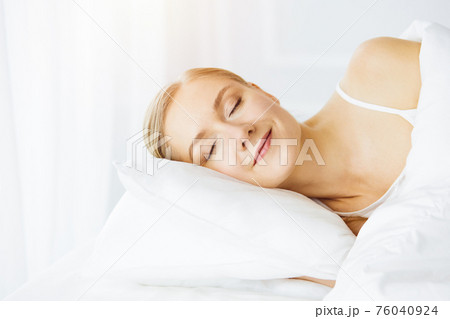 Beautiful young woman sleeping in bedroom comfortably and blissfully Beautiful young woman sleeping in bedroom comfortably and blissfully 76040924