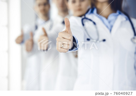 Group of modern doctors standing as a team with thumbs up in hospital office. Medical help, insurance in health care, best desease treatment and medicine concept 76040927