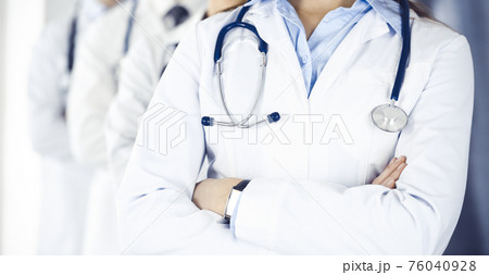 Group of modern doctors standing as a team with arms crossed in hospital office. Medical help, insurance in health care, best desease treatment and medicine concept 76040928