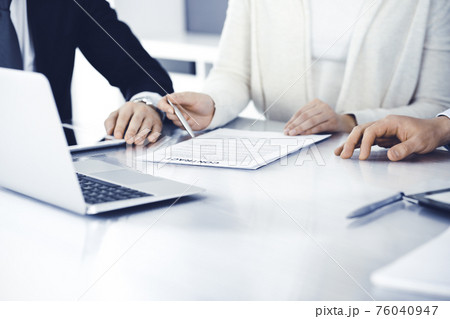 Business people discussing contract working together at meeting in modern office. Unknown businessman and woman with colleagues or lawyers at negotiation Business people discussing contract working together at meeting in modern office. Unknown businessman and woman with colleagues or lawyers at negotiation 76040947
