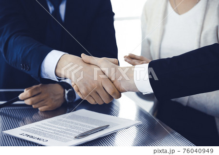Business people shaking hands after contract signing in modern office. Teamwork, partnership and handshake concept Business people shaking hands after contract signing in modern office. Teamwork, partnership and handshake concept 76040949