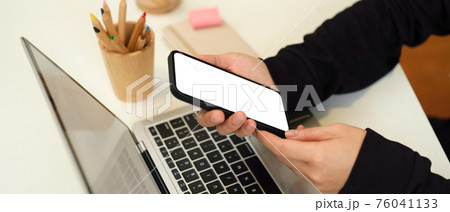 Female hands using smartphone include clipping path while working with laptop and stationery 76041133