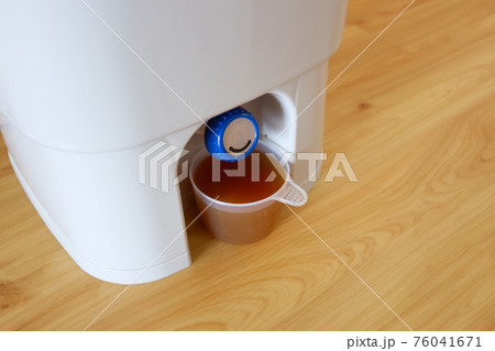 ぼかしコンポスト容器から液体肥料を抽出中 76041671