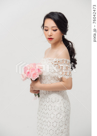 Fashion portrait of elegant woman with rose flower bouquet over white background. Fashion portrait of elegant woman with rose flower bouquet over white background. 76042473