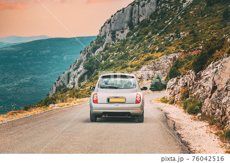 Verdon, France. Small car on road on background of French mountain nature landscape the Gorges Du Verdon in France. Altered Sunset Sky Verdon, France. Small car on road on background of French mountain nature landscape the Gorges Du Verdon in France. Altered Sunset Sky 76042516