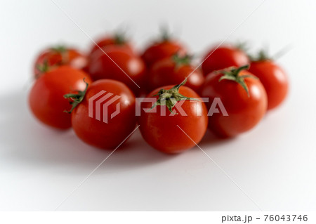 白い背景で撮影された沢山の新鮮なプチトマト 76043746