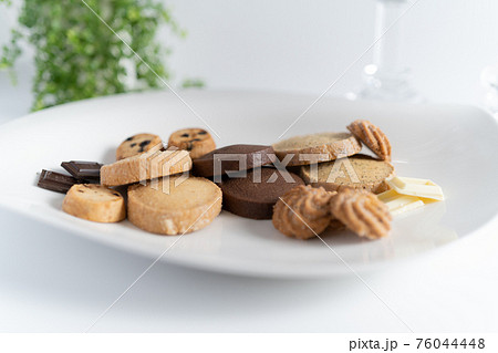 白い背景で白いお皿に盛り付けられたチョコレートとクッキーのお菓子の写真素材