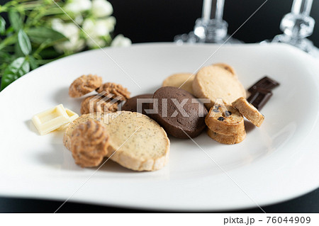 黒い背景に白いお皿に盛り付けられたチョコレートとクッキーの写真素材