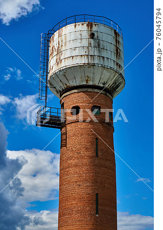 Water tower made of brick and metal with round windows 76045794