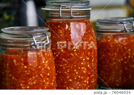Canning the hot pepper. Glass jars with hot pepper. Hot sauce in jars Canning the hot pepper. Glass jars with hot pepper. Hot sauce in jars 76046034