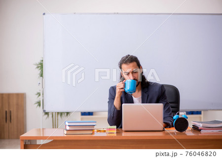 Young male teacher in the classroom 76046820