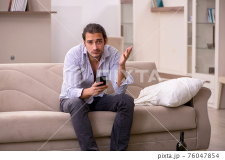 Young drunk man suffering at home 76047854