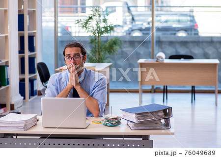 Young male accountant working in the office Young male accountant working in the office 76049689