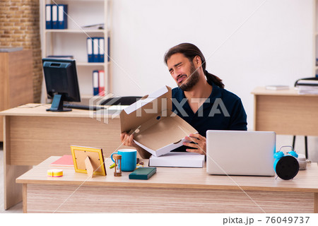 Young male employee ordering pizza at workplace 76049737