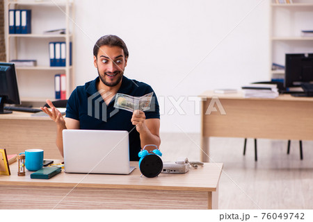Young male employee holding banknote in the office 76049742