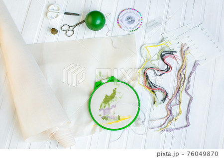 Embroidery hoop with blank fabric, colored sewing threads and various sewing buttons Embroidery hoop with blank fabric, colored sewing threads and various sewing buttons 76049870