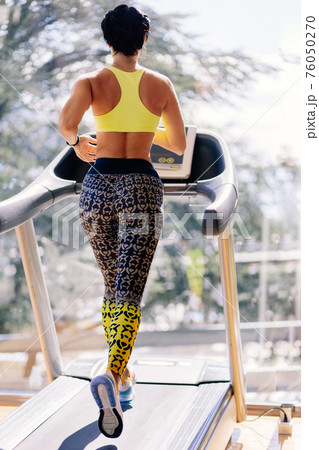 young attractive woman running on treadmill in sport gym young attractive woman running on treadmill in sport gym 76050270