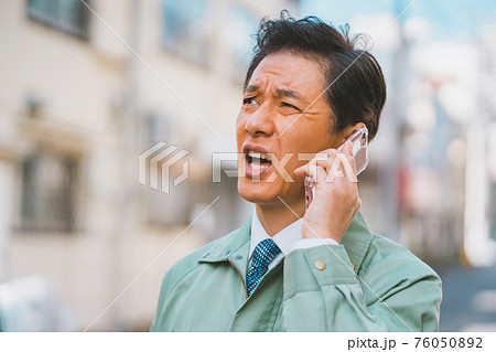 作業服にネクタイ姿の男性がスマホ通話 作業服にネクタイ姿の男性がスマホ通話 76050892