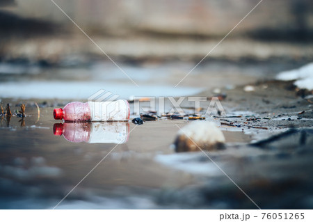 Abandoned empty pink plastic bottle garbage at the river bank conservancy pollution Abandoned empty pink plastic bottle garbage at the river bank conservancy pollution 76051265