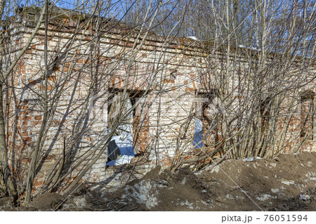 Part of the old facade of an abandoned stone house 76051594