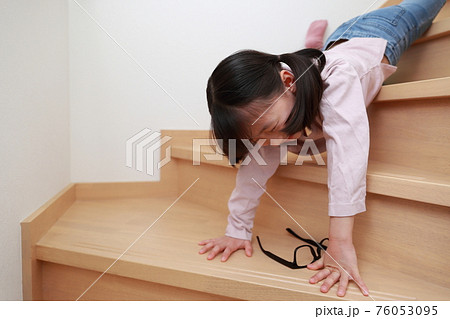 自宅の階段から落ちる幼児の女の子の写真素材