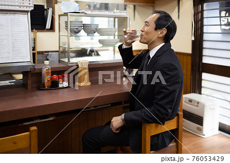 定食屋でお冷やを飲むサラリーマン 定食屋でお冷やを飲むサラリーマン 76053429